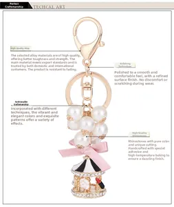 Detalle del llavero de carrusel con perlas, lazo rosa y cristales brillantes