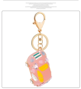 Close-up of a pink beetle car keychain adorned with colorful gemstones and rhinestones