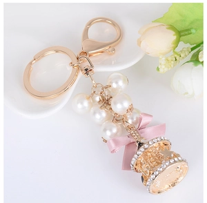 Detail of carousel keychain with pearl beads, pink silk bow and rhinestone accents