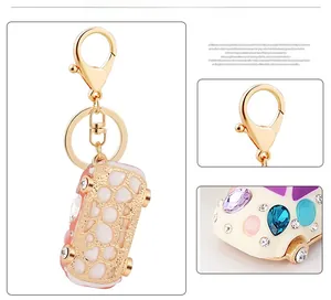 Close-up detail of pink enamel beetle car keychain with sparkling inlaid rhinestones