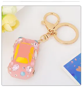 Detail of pink rhinestone car keychain with golden spring hook and decorative crystals