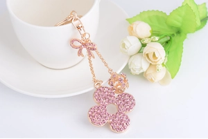 Close-up of pink rhinestone flower keychain with a delicate bow and golden clasp