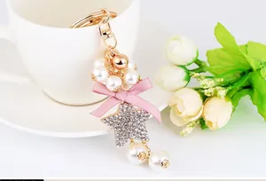 Close-up of rhinestone star keychain with pink ribbon bow and white faux pearls