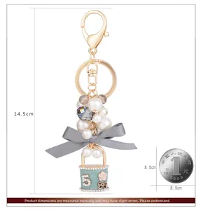 Détail du porte-clés élégant de 14,5cm avec nœud gris, perles et pendentif numéro 5 menthe