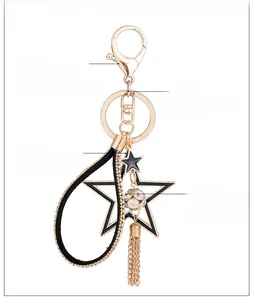 Dettaglio portachiavi a stella color oro con sfera di cristallo e lunghe nappe metalliche