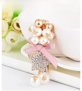 Macro detail of beaded keychain with pink bow and rhinestone star hanging on cup