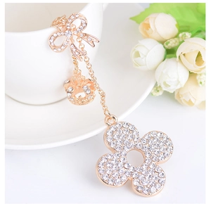 Macro detail of a sparkling golden four-leaf clover keychain with rhinestones and crown