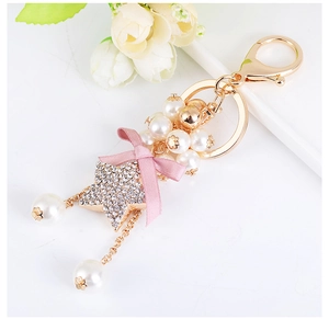 Close-up of pink ribbon bow and star charm on beaded pearl keychain for bags