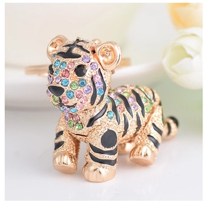 Macro detail of gold tiger keychain featuring multicolored crystals and intricate metalwork