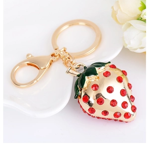 Close-up of sparkling red rhinestone strawberry keychain with gold lobster clasp