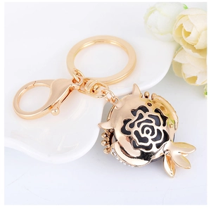 Detailansicht goldener Granatapfel-Schlüsselanhänger mit schwarzer Rose und Kristallen
