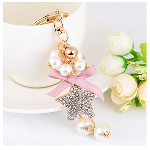 Detail of beaded star keychain with pink satin bow and luxury white pearls for bags