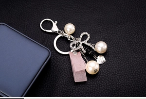 Detail of pearl keychain with rhinestone bow, pink ribbon and Sisters Always heart charm