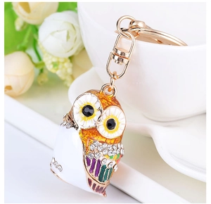Macro detail of owl keychain with colorful enamel coating and sparkling rhinestones