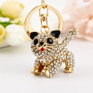 Macro shot of gold cat keychain with sparkling crystals and black enamel details