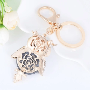 Detailansicht eines goldenen Eulen-Schlüsselanhängers mit Rosenmuster und Strasssteinen