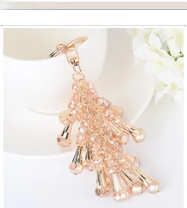 Detail of champagne gold crystal beaded tassel keychain with lobster clasp and metal charms
