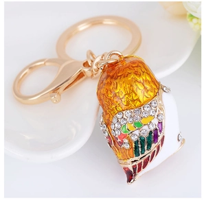 Detailed close-up of golden owl keychain with sparkling rhinestones and colorful enamel