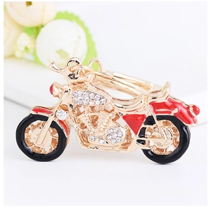 Détail du porte-clés moto en alliage doré avec strass blancs et finition émail rouge