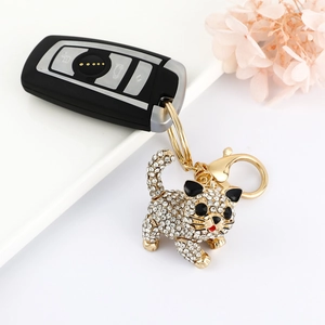 Close-up of a sparkling 3D cat keychain with white rhinestones on a BMW car key