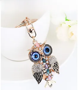 Macro detail of owl keychain featuring evil eye design and colorful crystal inlays