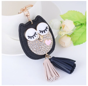 Détail du porte-clés hibou avec strass, cœur rose et pompons bicolores élégants