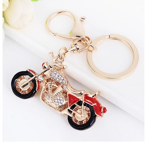 Détail du porte-clés moto rouge avec strass brillants et finition en alliage doré clair