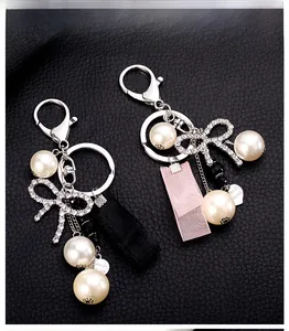 Detail of pearl keychain with rhinestone bow, satin ribbon, and metal heart pendant