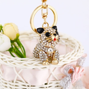 Detailed macro of crystal-studded tiger keychain with gold lobster clasp on white basket