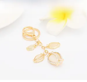 Detail of tulip keychain with cat-eye stones and crystal flower charms in gold finish