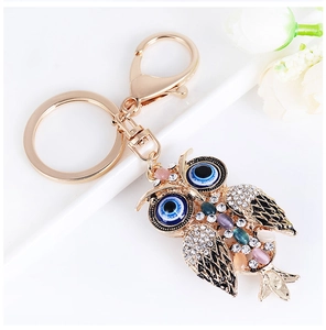 Detailed close-up of sparkling owl keychain with rhinestones and evil eye design