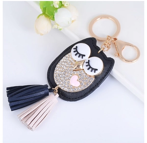 Détail du porte-clés hibou en cuir avec strass étincelants et pompons colorés