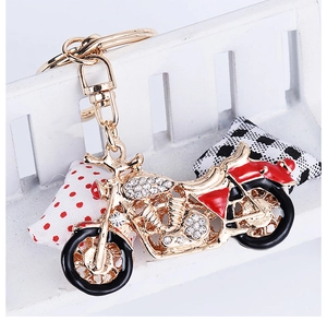 Détail d'un porte-clés moto créatif avec des strass blancs et un revêtement en émail rouge
