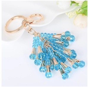 Macro detail of sky blue crystal bead tassel keychain with golden metal clasp