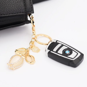 Close-up of a crystal tulip keychain with opal petals on a black leather car bag