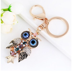 Close-up of owl keychain with colorful crystals, evil eye details and gold alloy clasp