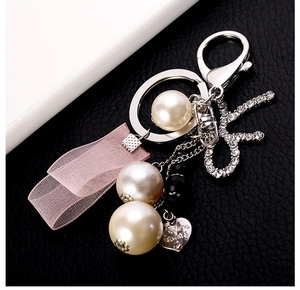 Detail of Sisters Always heart charm keychain with pink organza ribbon and pearl beads