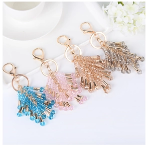 Detail of crystal beaded tassel keychains in navy blue, pink, champagne and silver grey