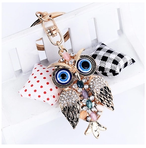 Detailed view of owl keychain with colorful cat eye stones and evil eye design