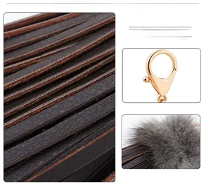 Détail d'un porte-clés à franges en cuir marron avec boucle dorée et décor en fourrure