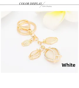 Detailed close-up of white cat eye stone tulip keychain with crystal rose gold plating