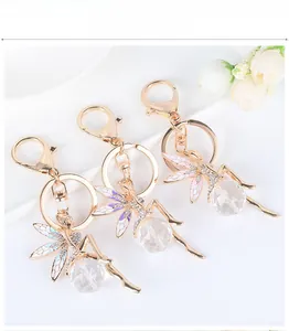 Detailed macro view of three ballet angel keychains with crystals and colorful wings