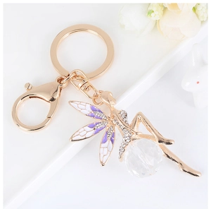 Detailed shot of golden angel keychain with purple wings, rhinestones and crystal ball
