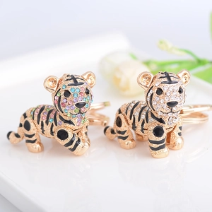 Luxe crystal tiger keychains with gold plating and colorful rhinestones on a white tray