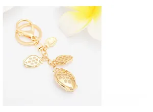 Detailed close-up of golden beetle charms with honeycomb hollow design on a keychain