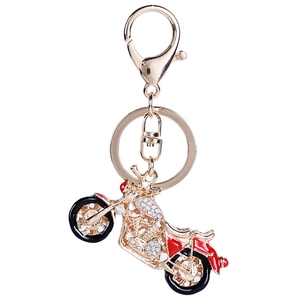 Porte-clés moto en alliage doré avec émail rouge et cristaux sur fond blanc