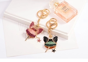 Close-up of fairy charms with rhinestones and star wands on gold alloy keychains
