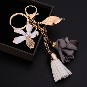 Elegant floral leaf keychain with tassels and pearls on a dark jewelry box