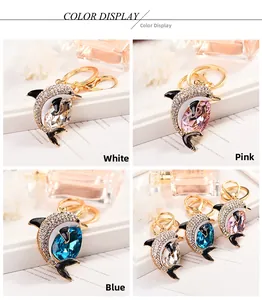 Detailed view of dolphin pendants with crystal-encrusted finish and large teardrop stones