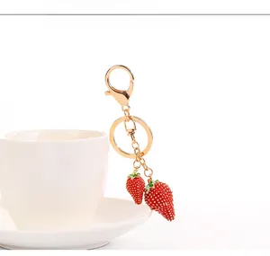 Dettaglio del portachiavi a fragola rossa con placcatura in oro su una tazza di ceramica
